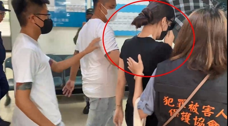 崁頂鄉代會主席楊芷瑜在白衣人撐傘刻意保護下，走進解剖室，由檢警確認丈夫陳昫豪的死者身分後步出解剖室，眼眶泛紅，手摀著口罩，低聲啜泣。石秀華／攝影