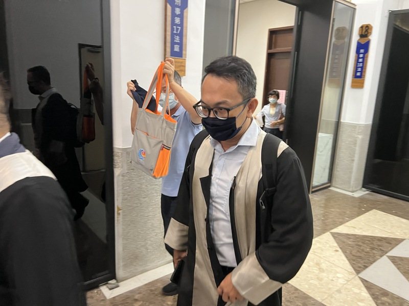富士康廣告公司吸金案主嫌李泰龍在二審審理時出庭，見媒體拍攝拿包包遮擋。圖／本報資料照