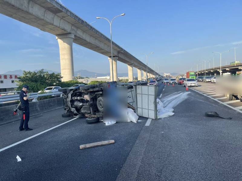 國道1號南向32.5公里汐五高架五股出口前，下午5時有1輛小貨車打滑失控翻覆，車上載運的麵粉撒落滿地，物品飛散波及另1輛轎車，幸好無人受傷，詳細肇事原因由國道警方調查中。記者林昭彰／翻攝