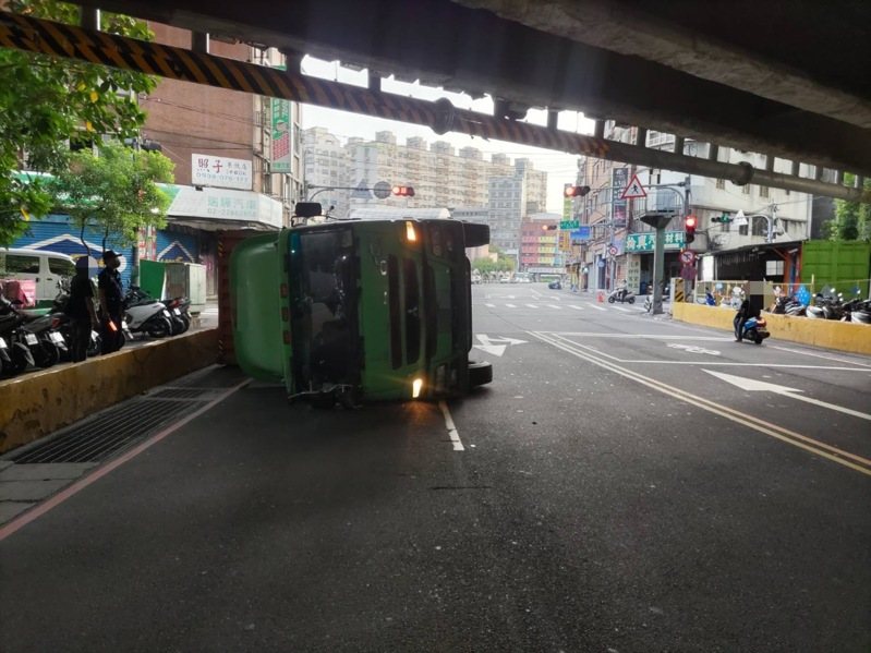 新北市今天清晨近6時,有1輛曳引貨櫃車在三重區自強路三段撞上高速公路涵洞的限高門架,導致車輛翻覆,幸未波及其他人車。貨櫃車於上午7時許拖離現場,交通恢復順暢。記者林昭彰/翻攝 新北市今天清晨近6時,有1輛曳引貨櫃車在三重區自強路三段撞上高速公路涵洞的限高門架,導致車輛翻覆,幸未波及其他人車。貨櫃車於上午7時許拖離現場,交通恢復順暢。記者林昭彰/翻攝