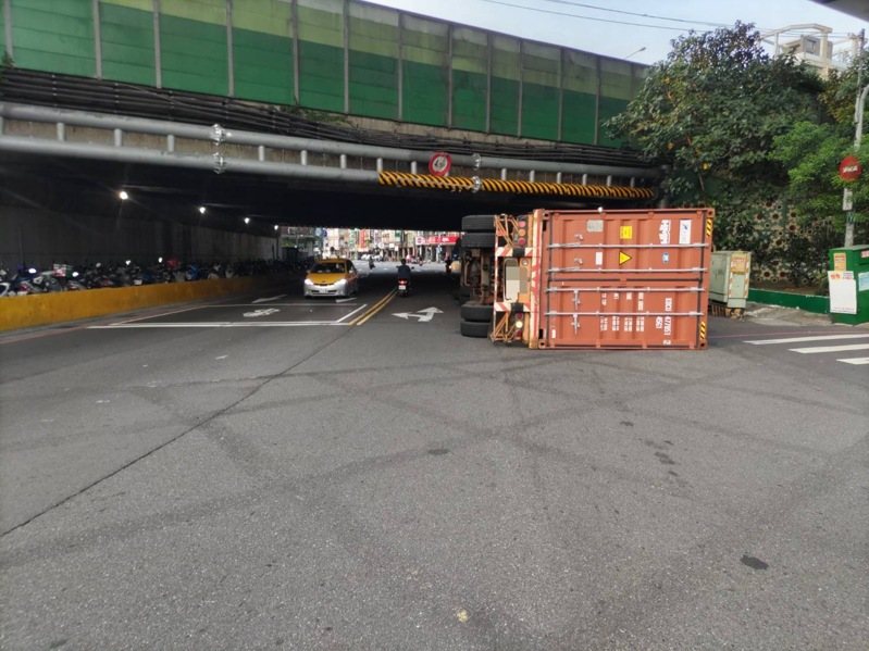 新北市今天清晨近6時,有1輛曳引貨櫃車在三重區自強路三段撞上高速公路涵洞的限高門架,導致車輛翻覆,幸未波及其他人車。貨櫃車於上午7時許拖離現場,交通恢復順暢。記者林昭彰/翻攝 新北市今天清晨近6時,有1輛曳引貨櫃車在三重區自強路三段撞上高速公路涵洞的限高門架,導致車輛翻覆,幸未波及其他人車。貨櫃車於上午7時許拖離現場,交通恢復順暢。記者林昭彰/翻攝