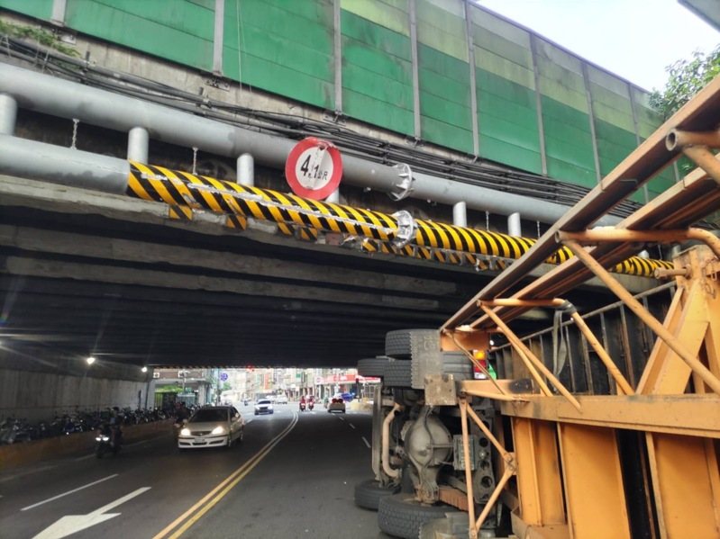 新北市今天清晨近6時,有1輛曳引貨櫃車在三重區自強路三段撞上高速公路涵洞的限高門架,導致車輛翻覆,幸未波及其他人車。貨櫃車於上午7時許拖離現場,交通恢復順暢。記者林昭彰/翻攝 新北市今天清晨近6時,有1輛曳引貨櫃車在三重區自強路三段撞上高速公路涵洞的限高門架,導致車輛翻覆,幸未波及其他人車。貨櫃車於上午7時許拖離現場,交通恢復順暢。記者林昭彰/翻攝