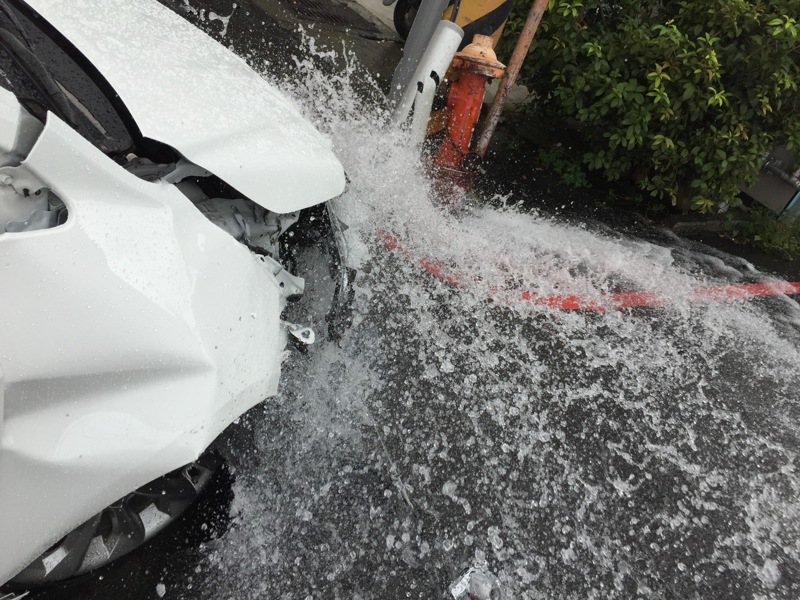 一名男子開車在豐原區，疑因閃避機車時不慎碰撞路旁消防栓，消防栓受損，水流噴出。記者游振昇／翻攝