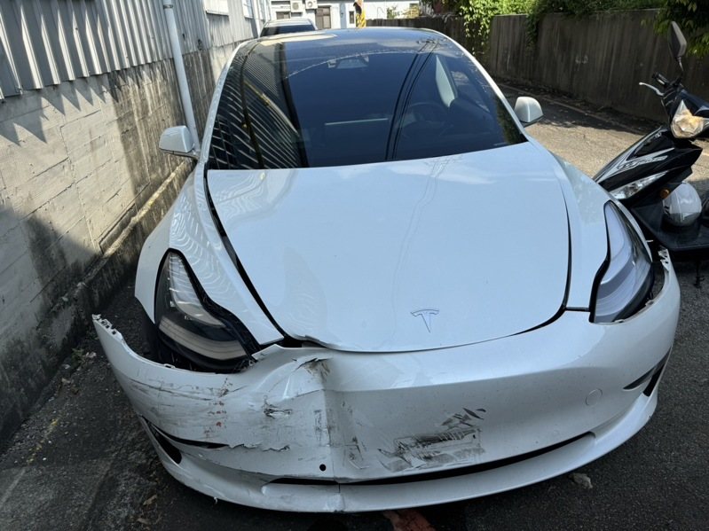 何男駕駛特斯拉發生車禍後,又不慎撞斷路燈,釀車頭凹損變形。記者曾健祐/翻攝 何男駕駛特斯拉發生車禍後,又不慎撞斷路燈,釀車頭凹損變形。記者曾健祐/翻攝