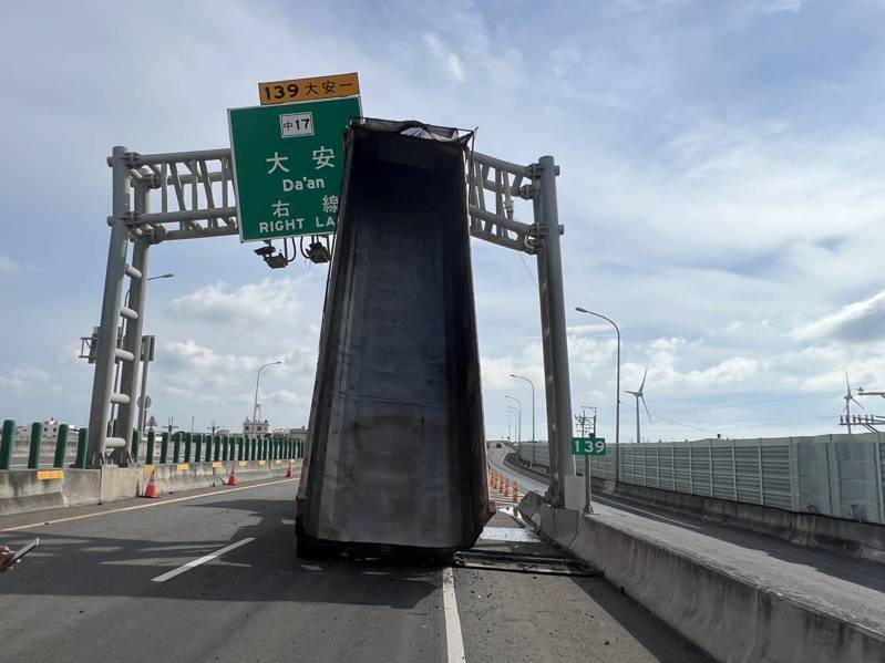 一輛曳引車今天行經台中市大安區五甲北路與西濱公路平面路口時，因後車斗的電動棚架故障自動升起，勾到該址位於中央分隔島上號誌桿，號誌桿彎曲電線垂吊於西濱公路平面道路與五甲南下上車道上。圖／警方提供