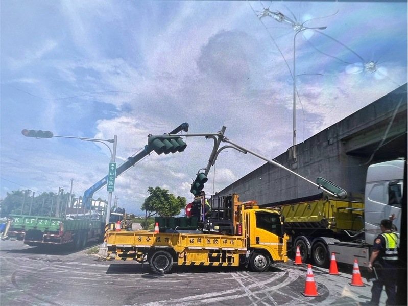 一輛曳引車今天行經台中市大安區五甲北路與西濱公路平面路口時，因後車斗的電動棚架故障自動升起，勾到該址位於中央分隔島上號誌桿，號誌桿彎曲電線垂吊於西濱公路平面道路與五甲南下上車道上。圖／警方提供