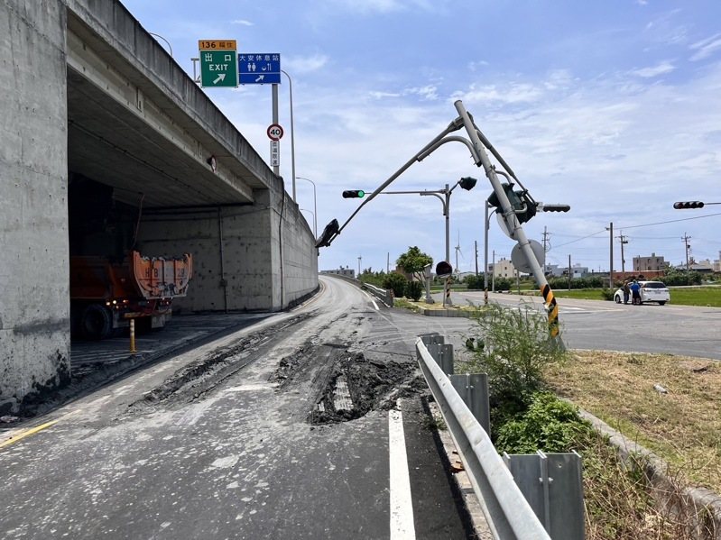 一輛曳引車今天行經台中市大安區五甲北路與西濱公路平面路口時，因後車斗的電動棚架故障自動升起，勾到該址位於中央分隔島上號誌桿，號誌桿彎曲電線垂吊於西濱公路平面道路與五甲南下上車道上。圖／警方提供