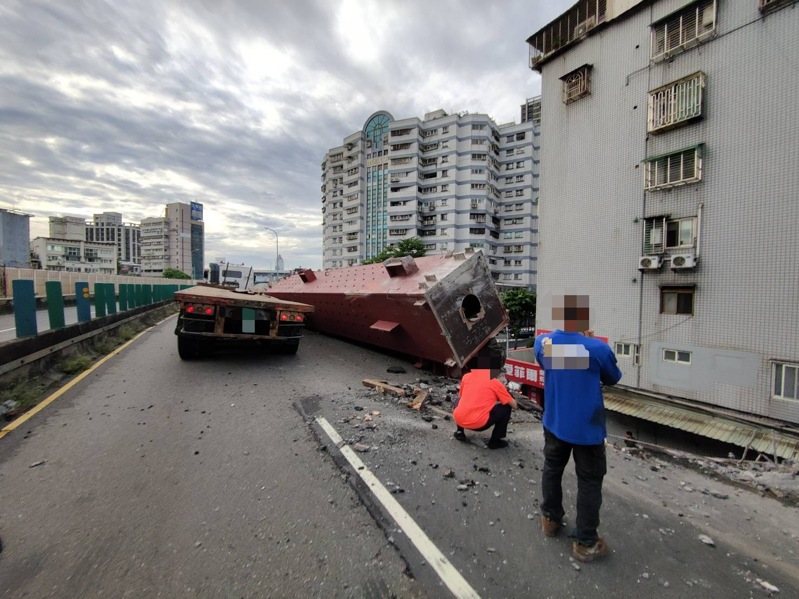 一輛聯結車今天清晨自撞新北市台一高架隔音防護牆，導致車鈄鋼梁傾斜掉落橋下壓毀兩輛汽車，現場無人受傷，肇因待查。記者曾伯愷／翻攝