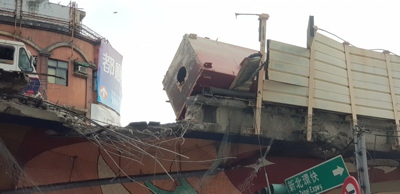 一輛聯結車今天清晨自撞新北市台一高架隔音防護牆,導致車鈄鋼樑傾斜掉落橋下壓毀兩輛汽車,現場無人受傷,肇因待查。記者曾伯愷/攝影 一輛聯結車今天清晨自撞新北市台一高架隔音防護牆,導致車鈄鋼樑傾斜掉落橋下壓毀兩輛汽車,現場無人受傷,肇因待查。記者曾伯愷/攝影