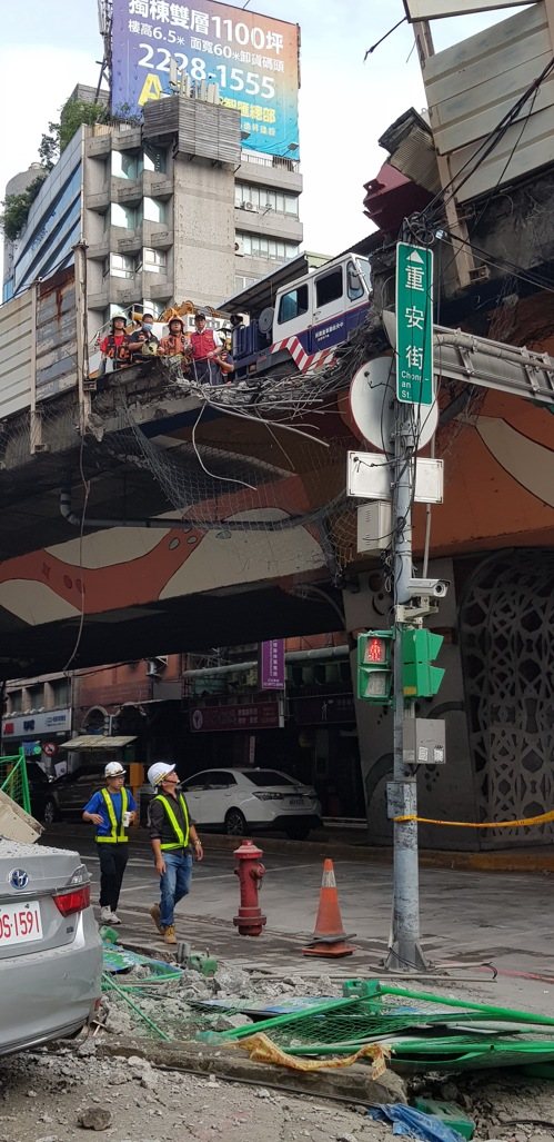 一輛聯結車今天清晨自撞新北市台一高架隔音防護牆，導致車鈄鋼樑傾斜掉落橋下壓毀兩輛汽車，現場無人受傷，肇因待查。記者曾伯愷／攝影