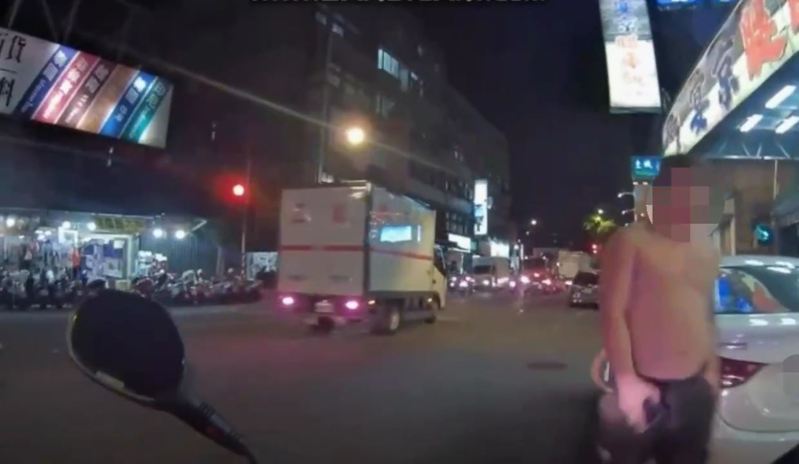 警方見赤裸上身的江男形跡可疑,站在違停車旁立即上前盤查。記者黃子騰/翻攝 警方見赤裸上身的江男形跡可疑,站在違停車旁立即上前盤查。記者黃子騰/翻攝