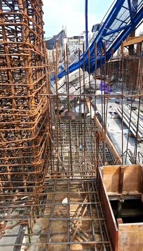 高雄三井商場工程今天上午9時許傳出工安意外，工地施工的藍色吊塔突倒塌掉落橫躺在鷹架、模板和一片鋼筋之中，意外造成工人1死1重傷。圖／取自記者爆料網