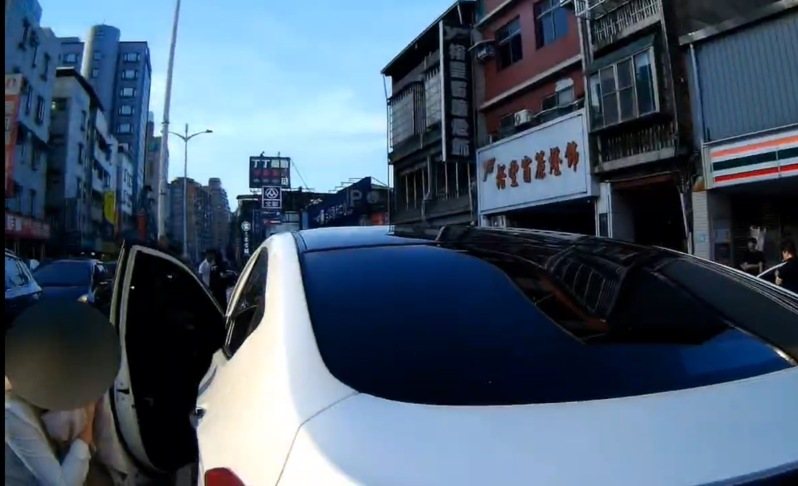 桃園市桃園區春日路昨傍晚發生行車糾紛，留著一頭金色長髮的楊男，噴辣椒水當下自己也吸入不適，蹲坐車門旁等候警方處理。記者陳恩惠／翻攝