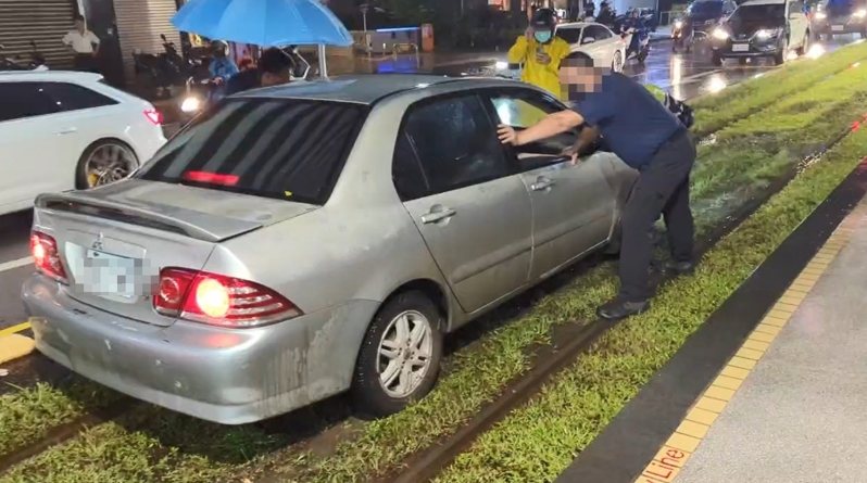 高雄市今晚遭豪大雨狂炸,潘姓男子駕車行經博愛一路左轉大順一路時,因下雨視線不清,整輛車駛入輕軌軌道區卡住,動彈不得。記者石秀華/翻攝 高雄市今晚遭豪大雨狂炸,潘姓男子駕車行經博愛一路左轉大順一路時,因下雨視線不清,整輛車駛入輕軌軌道區卡住,動彈不得。記者石秀華/翻攝