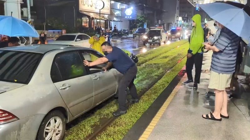 高雄市今晚遭豪大雨狂炸,潘姓男子駕車行經博愛一路左轉大順一路時,因下雨視線不清,整輛車駛入輕軌軌道區卡住,動彈不得。記者石秀華/翻攝 高雄市今晚遭豪大雨狂炸,潘姓男子駕車行經博愛一路左轉大順一路時,因下雨視線不清,整輛車駛入輕軌軌道區卡住,動彈不得。記者石秀華/翻攝