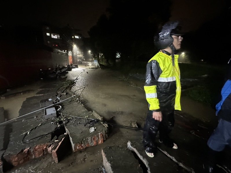 新北市汐止區茄苳路中央標準局辦公廳舍的圍牆，今晚被洪水推倒，積水宣洩而出，波及停在圍牆外中華街的機車，並造成積水。圖／張錦豪提供
