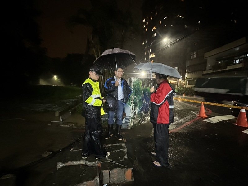 新北市汐止區茄苳路中央標準局辦公廳舍的圍牆，今晚被洪水推倒，積水宣洩而出，波及停在圍牆外中華街的機車，並造成積水。圖／張錦豪提供