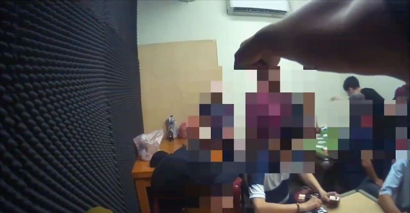 警方衝入賭場喝令賭客不准動。記者黃子騰/翻攝 警方衝入賭場喝令賭客不准動。記者黃子騰/翻攝