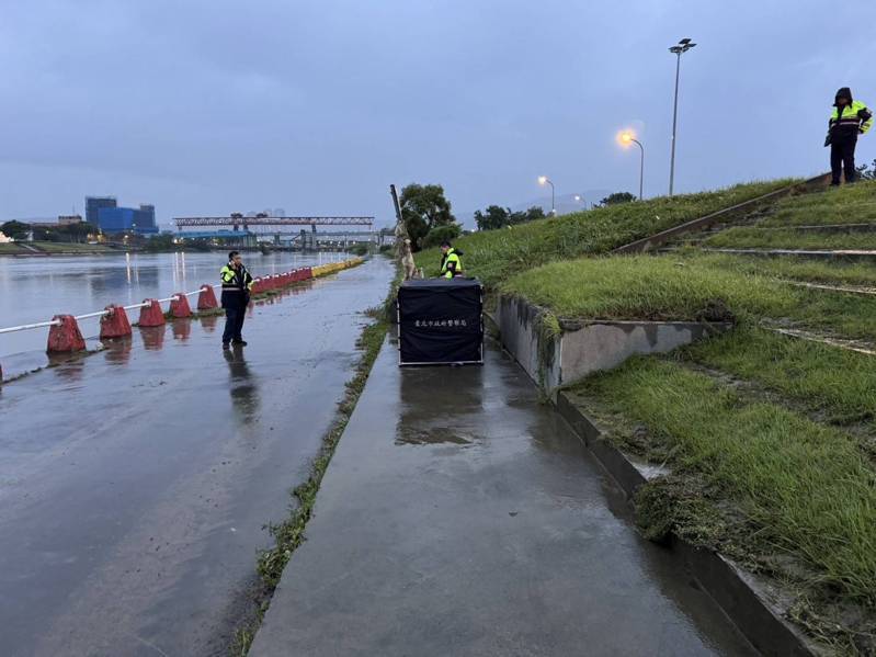 台北市民權大橋下方基隆河今下午出現一名中年男子載浮載沉，消防人員將其固定岸邊，警方正追查身分。記者蕭雅娟／翻攝
