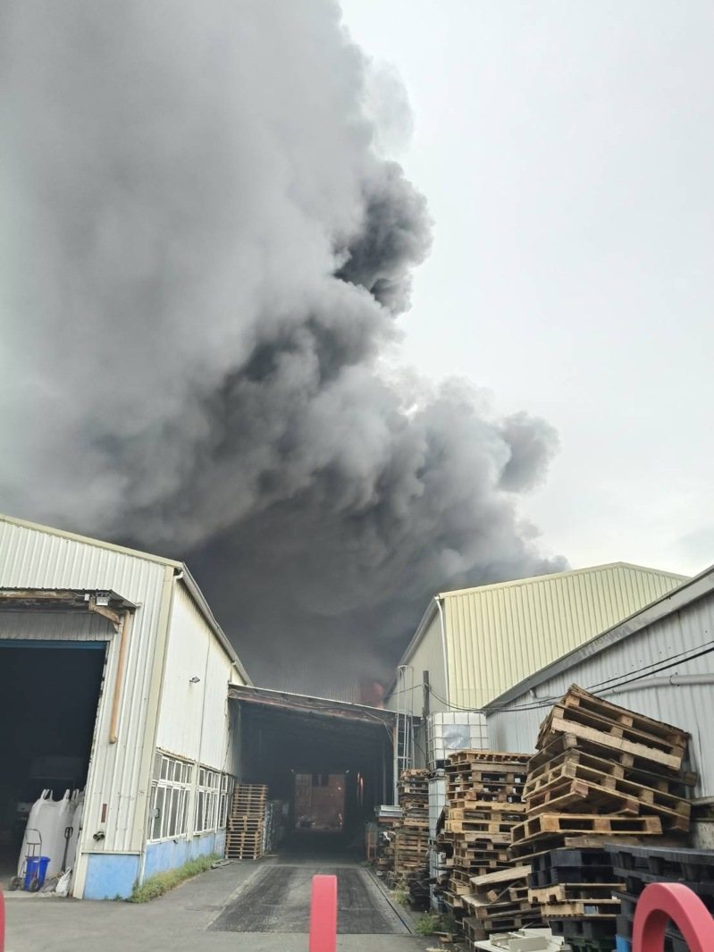 台南工廠有機溶劑起火爆炸，濃煙蔽天，消防員灑水警戒暫無法滅火。圖／讀者提供
