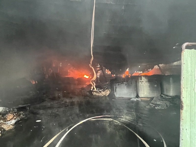 消防局據報，台南南區同興路上一家塑膠回收工廠冒出大量濃煙，廠內疑似燃燒塑膠粒料等，火勢一發不可收拾。圖／讀者提供
