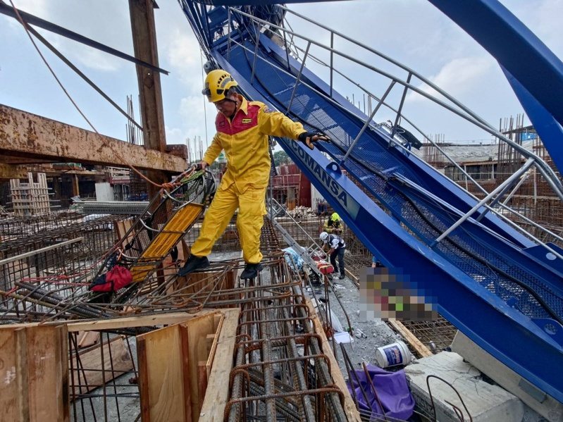 高雄三井商場工程昨天上午9點多傳出工安意外,工地施工的藍色吊塔突倒塌掉落橫躺在鷹架、模板和一片鋼筋之中,意外造成工人2死;圖為消防員救援畫面。記者石秀華/翻攝 高雄三井商場工程昨天上午9點多傳出工安意外,工地施工的藍色吊塔突倒塌掉落橫躺在鷹架、模板和一片鋼筋之中,意外造成工人2死;圖為消防員救援畫面。記者石秀華/翻攝