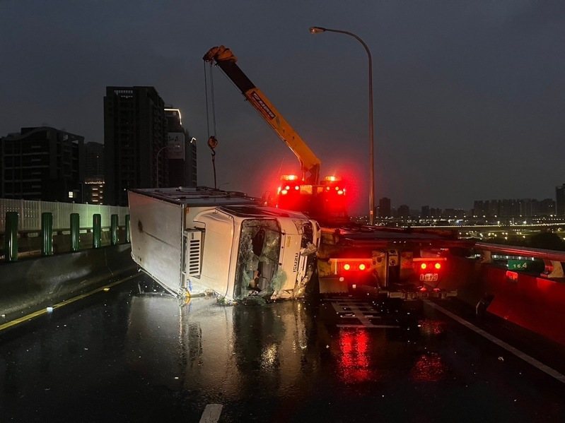 台64線快速道路三重路段往八里方向，凌晨4時許有1輛貨車自撞護欄翻車，導致後方另2輛貨車發生追撞，1人受傷送醫，並造成西向交通完全中斷約1個小時無法通行。記者林昭彰／翻攝