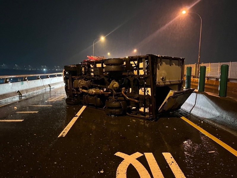 台64線快速道路三重路段往八里方向，凌晨4時許有1輛貨車自撞護欄翻車，導致後方另2輛貨車發生追撞，1人受傷送醫，並造成西向交通完全中斷約1個小時無法通行。記者林昭彰／翻攝