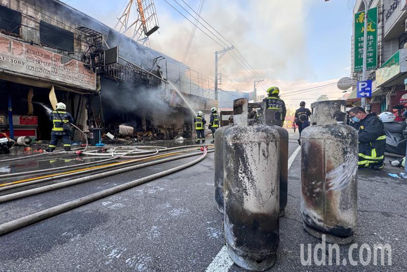 逢甲商圈傳出火警，消防員緊急將瓦斯圈搬離火場，避免火勢擴大。記者黃仲裕／攝影