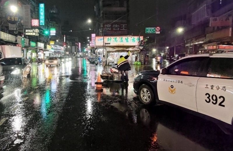 新北市三重區昨晚下大雨，中正北路旁1輛機車想要騎進對面巷子，卻未依道路標誌標線直接橫越馬路，造成另1輛直行機車緊急煞車摔倒、騎士受傷。記者林昭彰／翻攝