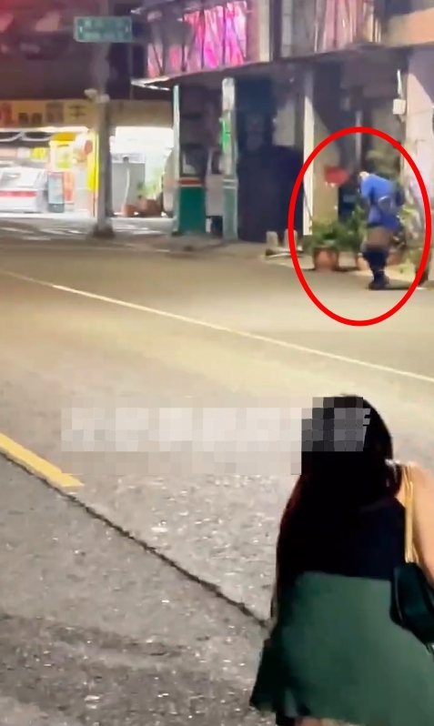高雄市一名身材高大的男子，今天清晨在三民區自立一路當街脫褲露臀，過街時手機掉落地面，女性友人幫忙撿起。圖／取自社群「社會事新聞影音」