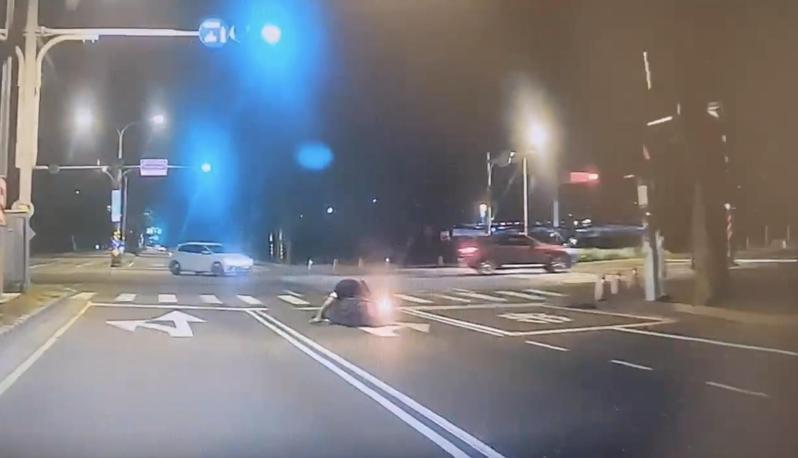 台南市警四分局育平派出所員警前晚巡邏時,發現前方1名機車騎士停等紅燈時,無故自摔倒地,擔心他發生意外,迅速下車上前了解狀況。記者邵心杰/翻攝 台南市警四分局育平派出所員警前晚巡邏時,發現前方1名機車騎士停等紅燈時,無故自摔倒地,擔心他發生意外,迅速下車上前了解狀況。記者邵心杰/翻攝