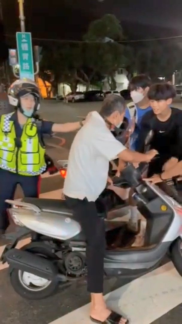 見義勇為的學生和民眾圍住騎士,協助女警將一把抓住騎士。圖/翻攝畫面 見義勇為的學生和民眾圍住騎士,協助女警將一把抓住騎士。圖/翻攝畫面