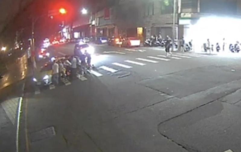 台中市陳姓男子今天凌晨駕駛計程車行經北區時迴轉,與楊姓機車騎士碰撞,楊被壓在車底,多名熱心市民合力抬車。記者陳宏睿/翻攝 台中市陳姓男子今天凌晨駕駛計程車行經北區時迴轉,與楊姓機車騎士碰撞,楊被壓在車底,多名熱心市民合力抬車。記者陳宏睿/翻攝