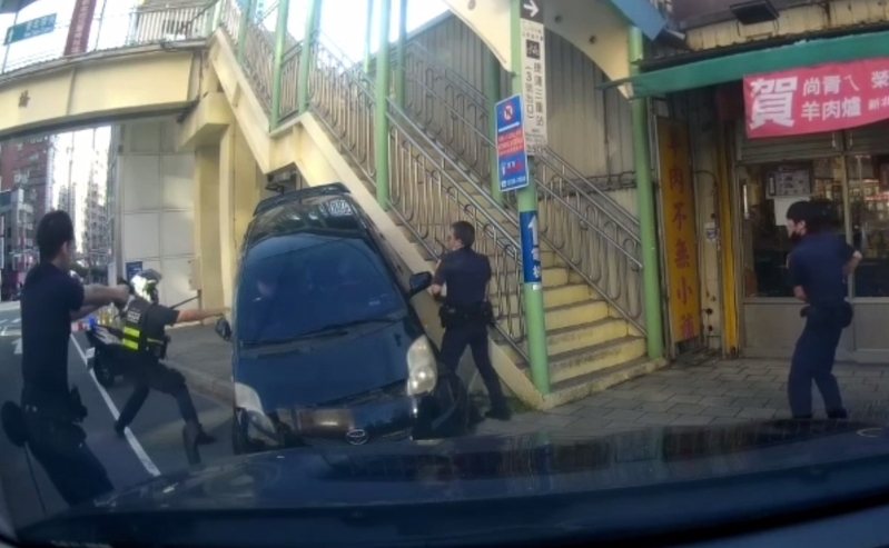 新北市警方下午在三重區中正北路某釣蝦場前，攔查可疑車輛連開2槍打破車胎仍被脫逃，警匪飛車追逐2.5公里，嫌犯逃到重陽路某羊肉爐店門前，再被連開7槍壓制逮捕；2名20歲男子坦承是詐騙集團車手。記者林昭彰／翻攝