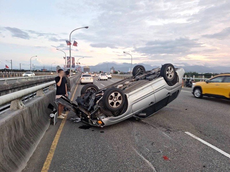 行駛中的機車掉落安全帽，帽子在路面滾跳，左方轎車為閃避自撞蘭陽橋護欄並翻車，四輪朝天。圖／警方提供