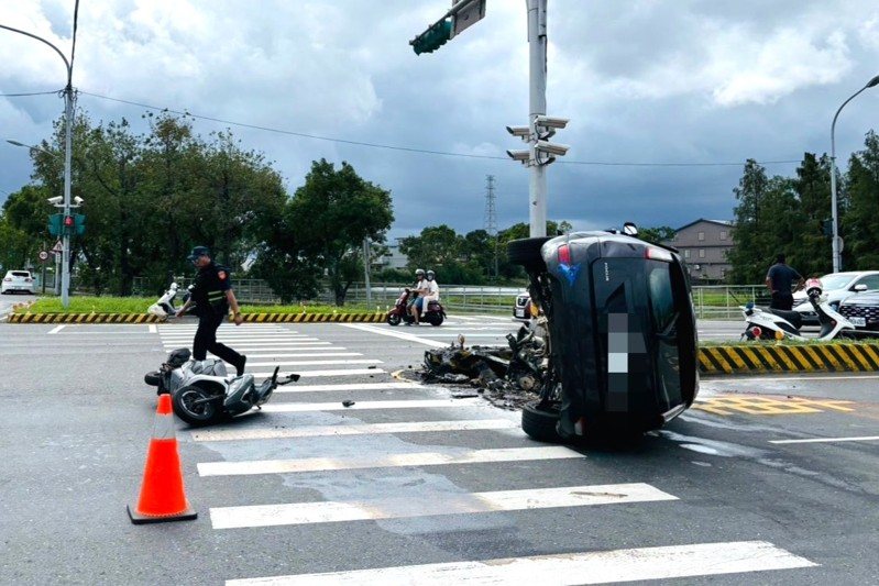 蘭陽橋頭附近，一輛疑似闖紅燈的自小客車碰撞機車後，失控再重撞號誌燈分隔島後側翻，車頭全撞爛並留有燒毀痕跡，所幸駕駛被附近民眾救出送醫。圖／警方提供