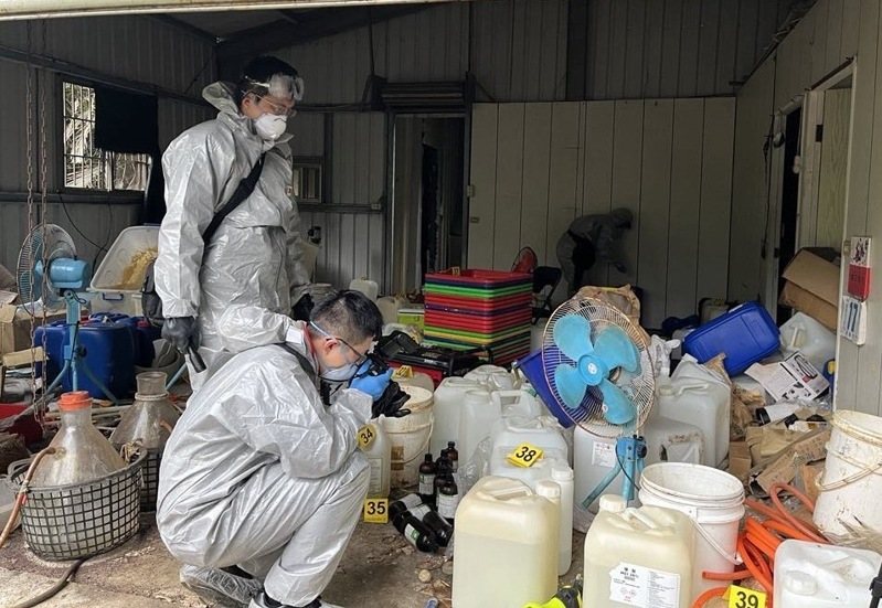 檢警聯手在中寮鄉查獲製毒工廠，為防治製毒所產生刺鼻的惡臭及大量濃煙，辦案人員需穿戴全身防護裝備。圖／南投縣警局提供