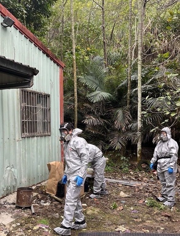 檢警聯手在中寮鄉查獲製毒工廠，為防治製毒所產生刺鼻的惡臭及大量濃煙，辦案人員需穿戴全身防護裝備。圖／南投縣警局提供