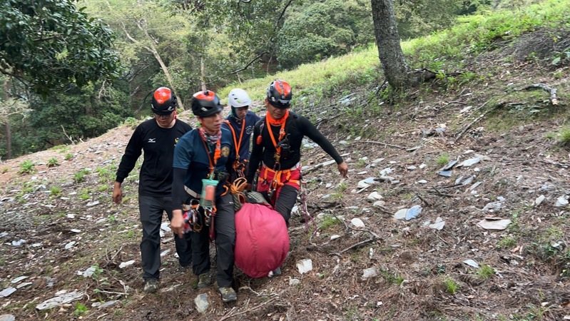 搜救人員將女山友遺體拉上步道，再送往無雙停機坪，運載下山。圖／南投縣消防局提供