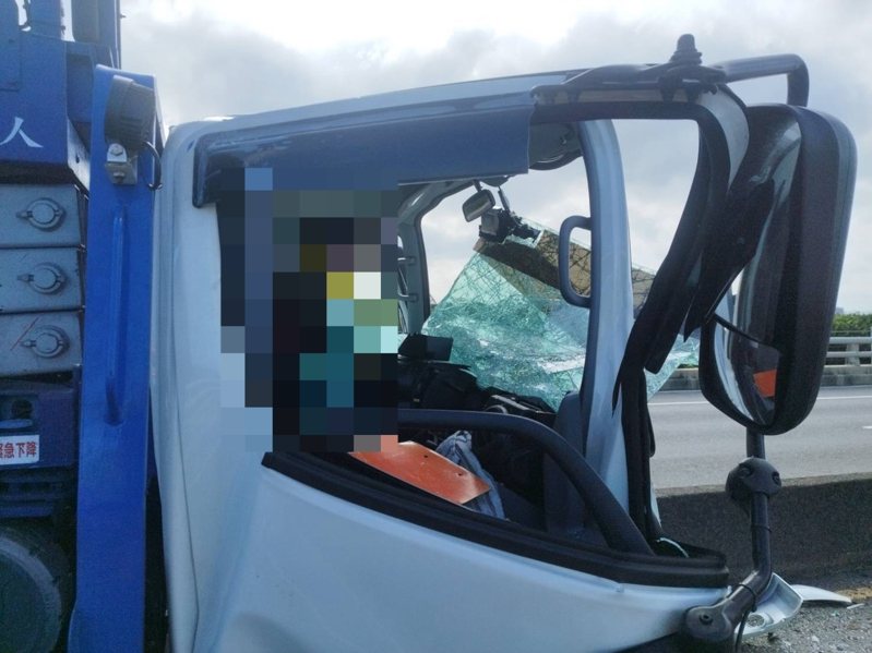 消防人員持破壞器材在現場撐開因追撞被夾扁的貨車頭，駕駛下半身被夾住，痛到只能在座位上呻吟待援。記者巫鴻瑋／翻攝