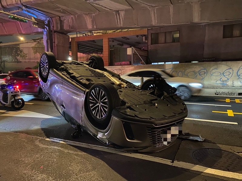 林姓男子今晚駕駛汽車沿台北市大同區環河北路一段往北行，自撞停放路邊的汽車後翻覆。記者李隆揆／翻攝