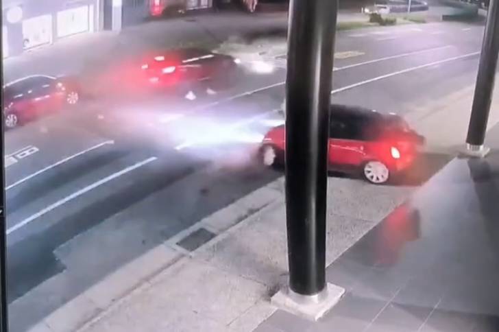 監視器畫面中，Mini Cooper連撞對向兩車後，衝到路邊一家車行的騎樓停下， 3輛紅車連環撞，過程相當嚇人。圖／翻攝監視器畫面