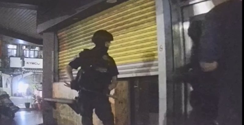 高市苓雅區建國一路一家粽子店一個月沒營業，2樓卻人聲鼎沸，警方前天凌晨執行搜索，保大特勤員警破門衝上樓，查獲天九牌賭場。記者石秀華／翻攝