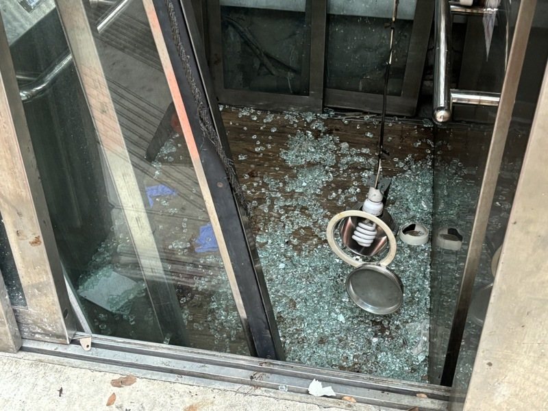 新北市板橋區捷運府中站2號出口附近,有一陸橋電梯27日發生故障急墜意外,造成55歲孫姓婦人腳部骨折,其8歲侄子則有撕裂傷。圖為電梯玻璃碎裂一地。中央社 新北市板橋區捷運府中站2號出口附近,有一陸橋電梯27日發生故障急墜意外,造成55歲孫姓婦人腳部骨折,其8歲侄子則有撕裂傷。圖為電梯玻璃碎裂一地。中央社