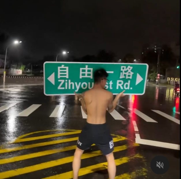 高雄市「自由一路」路牌遭山陀兒強風吹落,一名男子拾起,當街玩了起來。圖/取自社群Threads 高雄市「自由一路」路牌遭山陀兒強風吹落,一名男子拾起,當街玩了起來。圖/取自社群Threads
