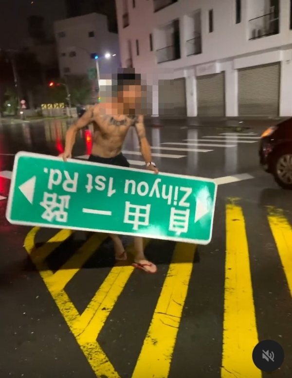 高雄市「自由一路」路牌遭山陀兒強風吹落,一名男子拾起,當街玩了起來。圖/取自社群Threads 高雄市「自由一路」路牌遭山陀兒強風吹落,一名男子拾起,當街玩了起來。圖/取自社群Threads