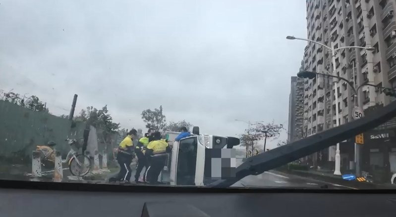 山陀兒颱風超強風雨驚人，近午時分登陸高雄，一輛小貨車行經前鎮區光華三路時，遭強風吹翻，馮姓駕駛受困車中；警方趕抵將馮救出。記者石秀華／翻攝