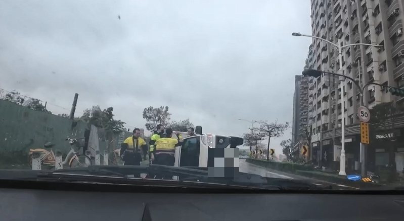 山陀兒颱風超強風雨驚人，近午時分登陸高雄，一輛小貨車行經前鎮區光華三路時，遭強風吹翻，馮姓駕駛受困車中；警方趕抵將馮救出。記者石秀華／翻攝